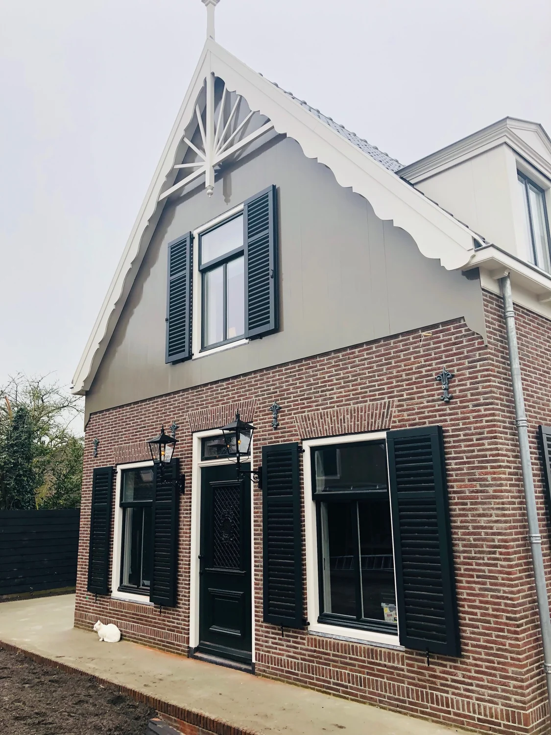 Lantaarns naast de entree van een woning met luiken.