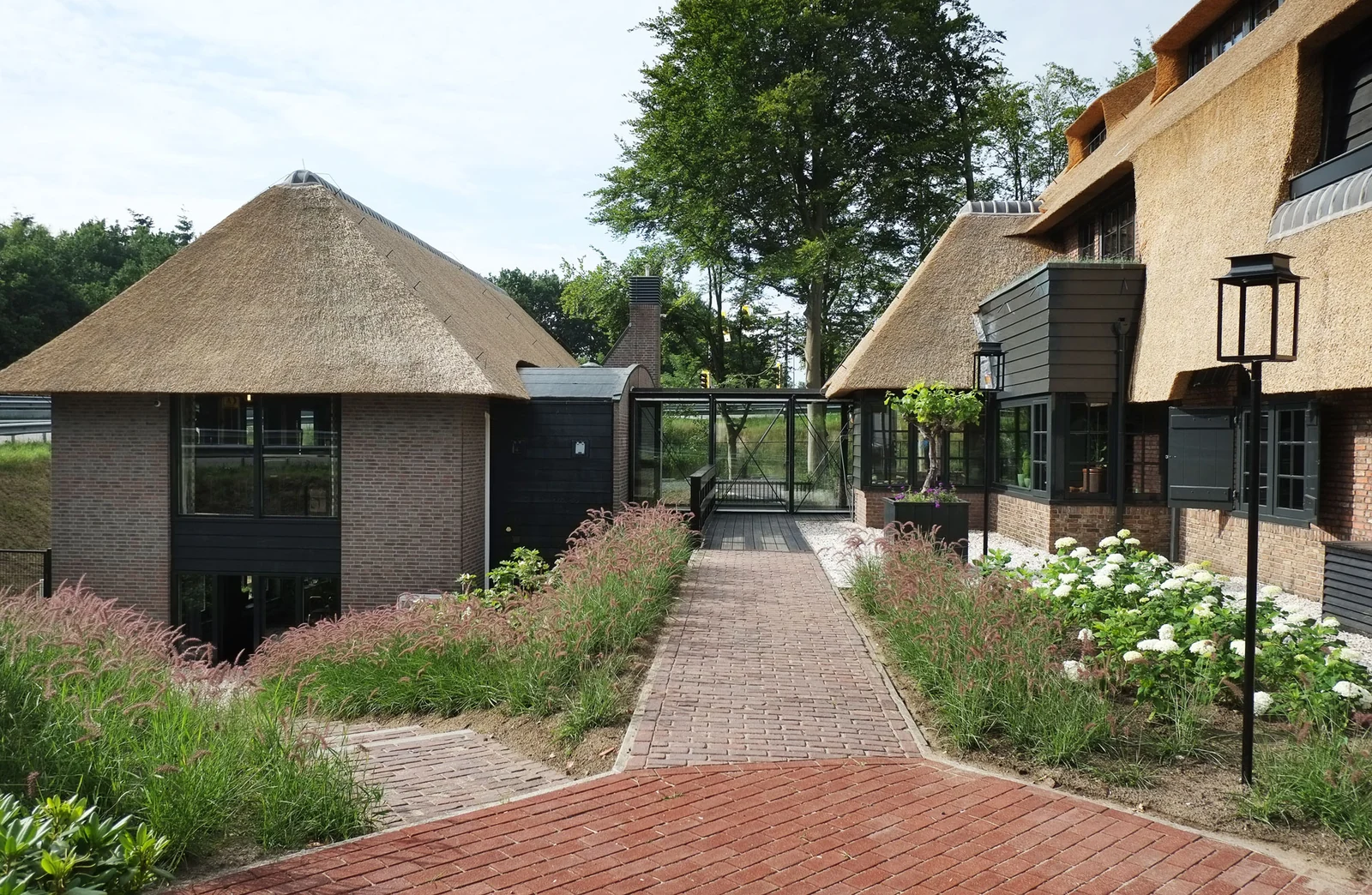 Lantaarns langs een tuinpad, met wandlampen aan de gevel.