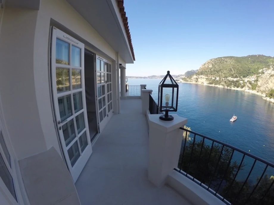 Jan des Bouvrie-lantaarn op een poer langs een balkon met uitzicht op zee.