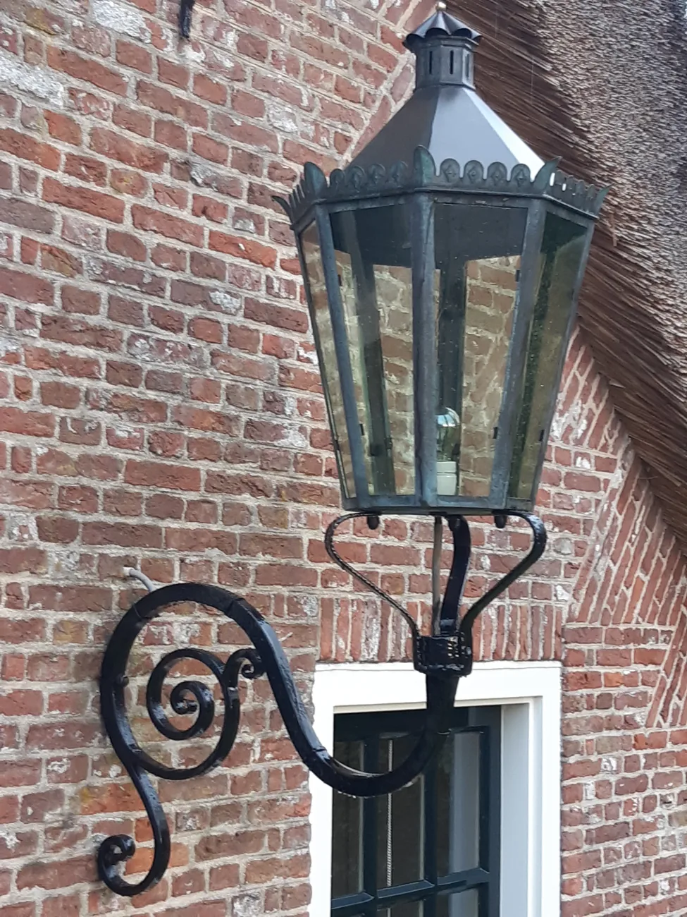De lantaarn in Loosdrecht na revisie, terug op de gevel met verzorgde afwerking en herstelde muurarm.